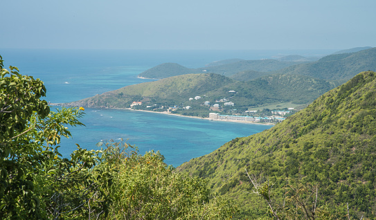 View from Goat Hill hike with lush, native greenery in the rolling landscape and the blue Caribbean Sea on St. Croix in the US Virgin Islands.