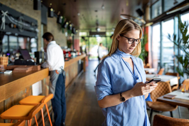 istock An Attractive Blonde Woman is Using her Mobile Phone for Online Browsing while Sitting in the Modern Cafe, but Looking Pensive. 1256116338