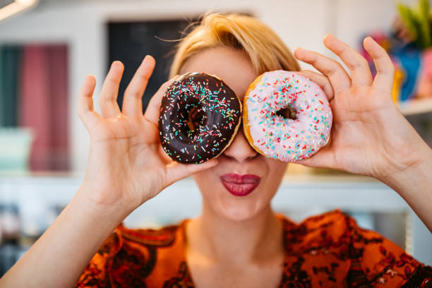 istock Woman covering her eyes with donuts 1256116839
