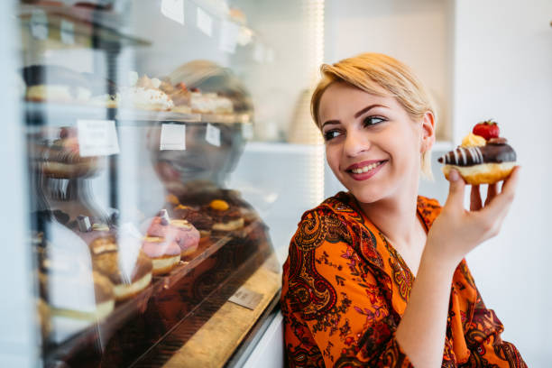 istock Woman eating donut at the bakery store 1256117428