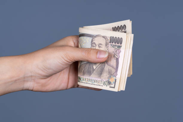 istock hand holding Japanese banknote 1256117828