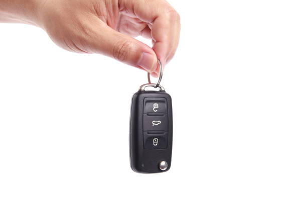 Man hand holding car key, isolated on white background