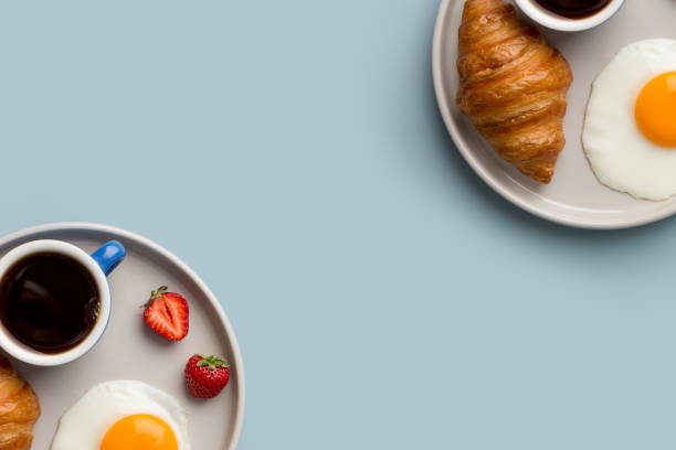 istock Two plates with continental breakfast on light blue minimal background 1256119222