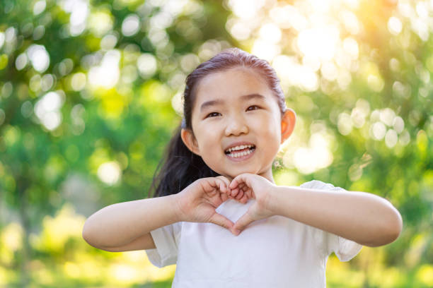 Little Girl Making Heart Shaped Gesture