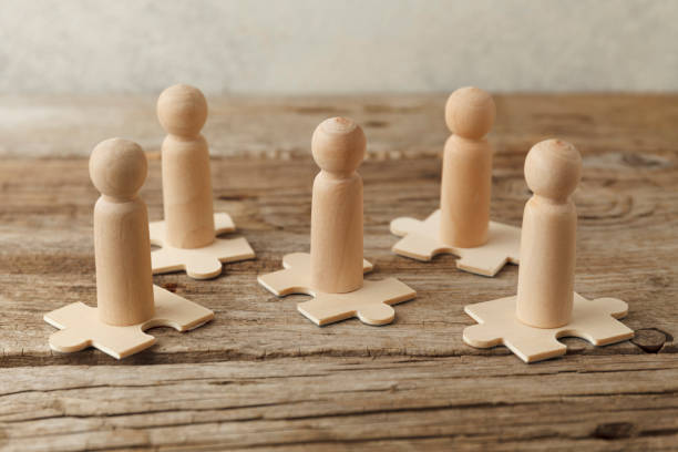 istock Wooden figures on puzzles. People analytics and optimization, team building. Group connection in business 1256122722