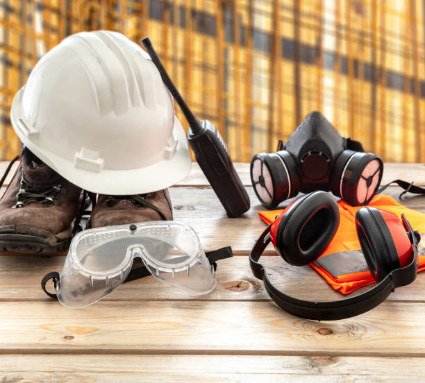 istock Work safety protection equipment. Industrial protective gear on wooden table, blur construction site background. 1256122889