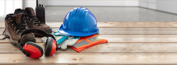 оборудование для защиты от безопасности труда. промышленное защитное снаряжение на деревянном столе, размытие фона участка. - blue helmets стоковые фото и изображения