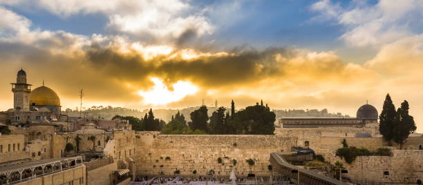 Sunrise over the Western/Wailling Wall and the Temple Mount Beautiful sunrise clouds over the Mount of Olives and the Temple Mount sites: Dome of the Rock, Western Wall and Al Aqsa Mosque; with Jewish people praying in sections because of covid-19 regulations wailing wall stock pictures, royalty-free photos & images