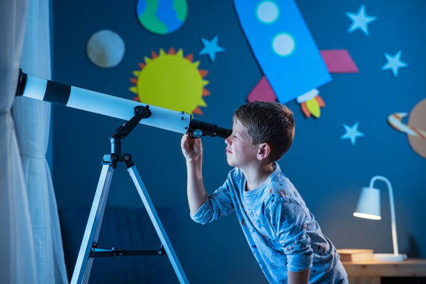 étoile de garçon regardant la nuit avec le télescope - astrolabe photos et images de collection