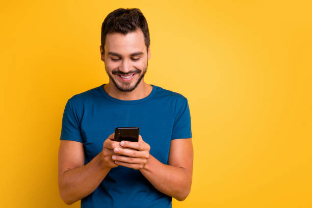 Close-up portrait of his he nice attractive focused cheerful cheery guy using device browsing web internet online wi-fi 5g isolated over bright vivid shine vibrant yellow color background