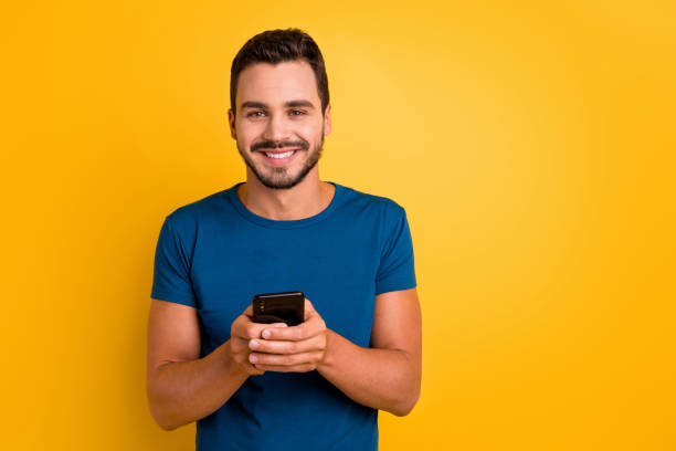 istock Close-up portrait of his he nice attractive glad cheerful cheery guy using cell comment feedback repost smm service isolated over bright vivid shine vibrant yellow color background 1256126851