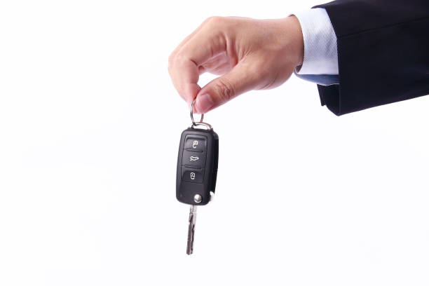 istock Man hand holding car key, isolated on white background 1256126855