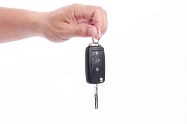 istock Man hand holding car key, isolated on white background 1256126857