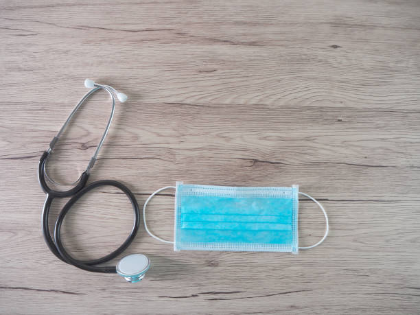 istock Masks and stethoscope on a wooden background medical concept. 1256128200