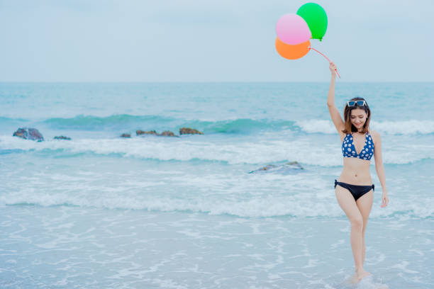 istock Asian woman on the beach 1256134113
