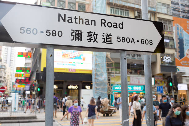 Hong Kong, Hong Kong - July 14, 2020 : People wearing face masks walk past Nathan Road in Mong Kok, Kowloon, Hong Kong.