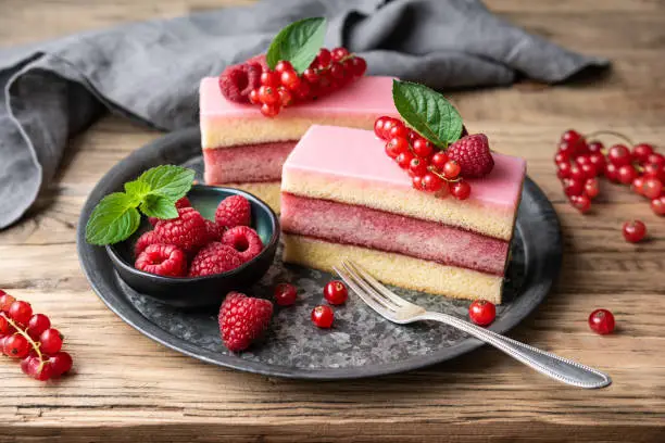 Photo of Delicious and refreshing juicy dessert, punch cake topped with sugar icing and fresh raspberries and red currants