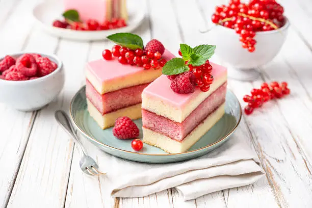 Photo of Delicious and refreshing juicy dessert, punch cake topped with sugar icing and fresh raspberries and red currants
