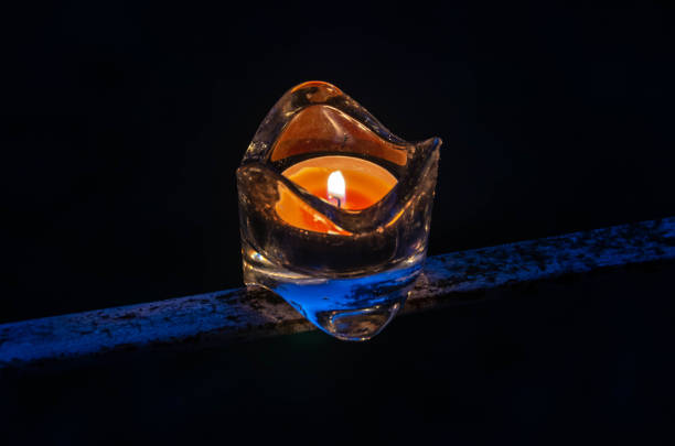 orange candle in glass on black bacground