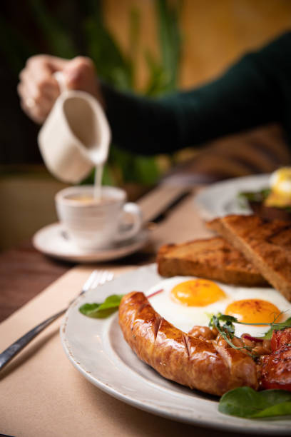istock Full English breakfast - fried egg, baked beans, bacon, sausages 1256139323