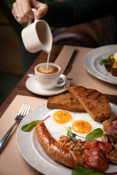 istock Full English breakfast - fried egg, baked beans, bacon, sausages 1256139330