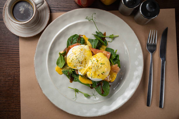 Poached eggs with salad and smoked salmon on a wooden table in a top restaurant