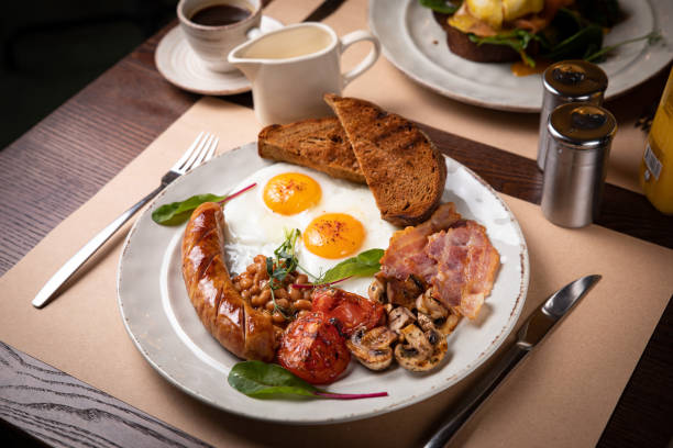 istock Full English breakfast - fried egg, baked beans, bacon, sausages 1256139357