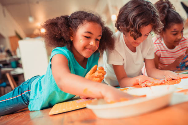 istock Group of children playing with bright paints 1256139382