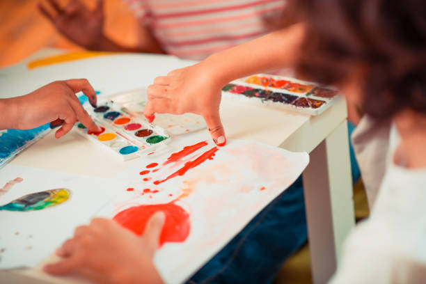 istock Kids learning to paint with their fingers 1256139482