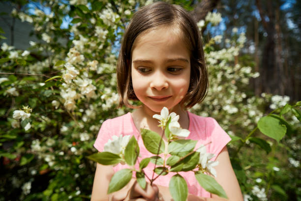 istock adorable girl making faces with jasmine flower 1256140341