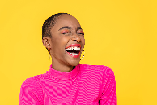 Feliz optimista mujer afroamericana en ropa rosa colorida riendo photo