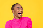 Happy optimistic African American woman in colorful pink clothes laughing