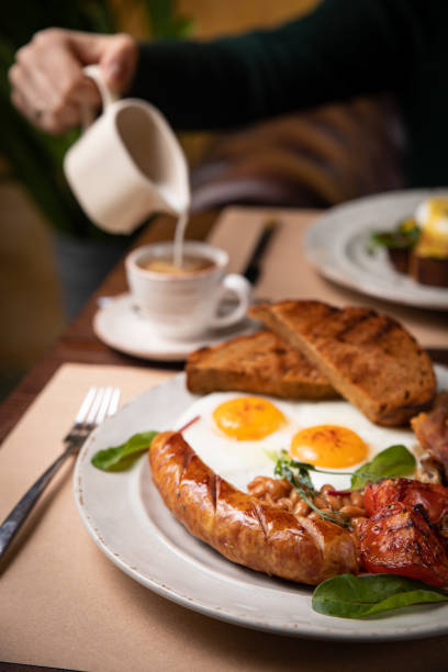istock Full English breakfast - fried egg, baked beans, bacon, sausages 1256141381