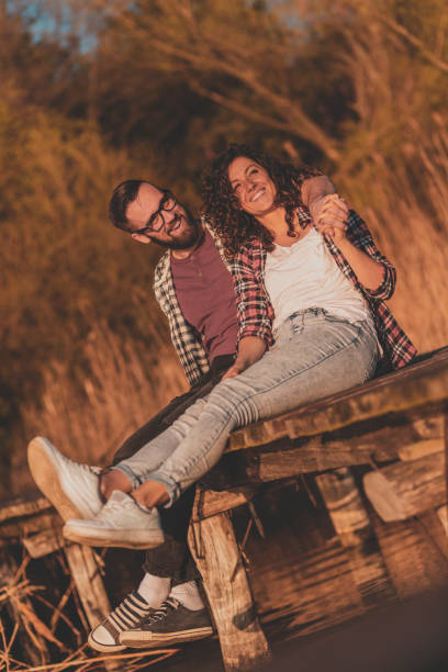 istock Couple enjoying autumn day at lake docks 1256141699