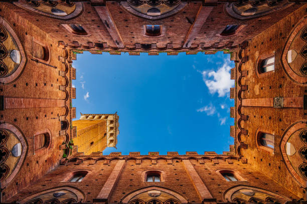 Directly below Torre del Mangia in Siena, Tuscany, Italy. View from the internal courtyard of the Town Hall in Siena.