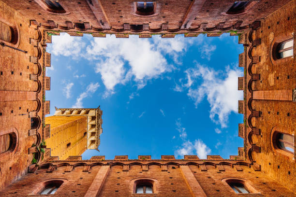 Directly below Torre del Mangia in Siena Directly below Torre del Mangia in Siena, Tuscany, Italy. View from the internal courtyard of the Town Hall in Siena. siena italy stock pictures, royalty-free photos & images