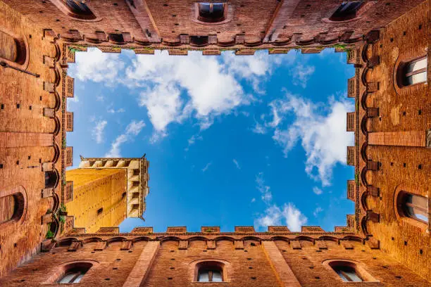 Directly below Torre del Mangia in Siena, Tuscany, Italy. View from the internal courtyard of the Town Hall in Siena.