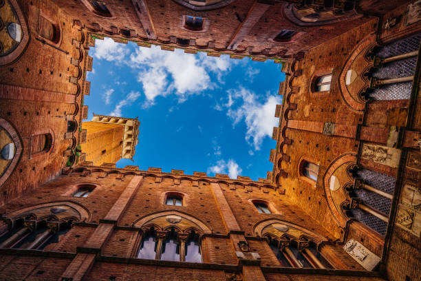 Directly below Torre del Mangia in Siena Directly below Torre del Mangia in Siena, Tuscany, Italy. View from the internal courtyard of the Town Hall in Siena. torre del mangia stock pictures, royalty-free photos & images