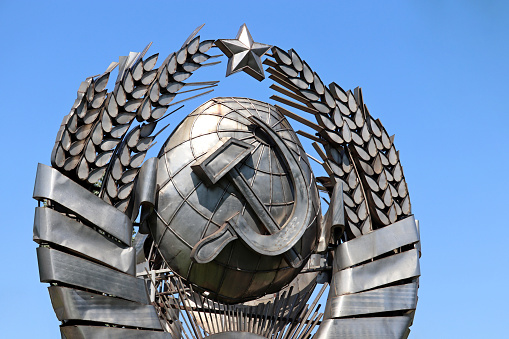 Metal soviet emblem on blue sky background