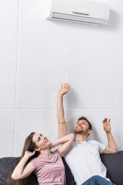 istock happy couple at home with air conditioner 1256148778
