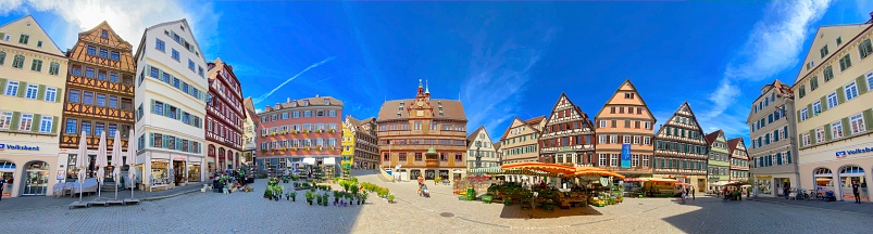 Tübingen, Germany - July, 13 - 2020: View of the town square and the townhall in the center. Typical half-timbered houses, market stands, shops, restaurants and tourists to be seen at this sunny summer day.