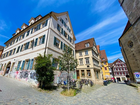 Tübingen, Germany - July, 13 - 2020: St. Georg church on the right side, on the left  a typical college dorm.