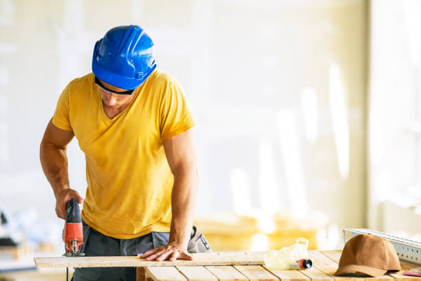 istock Manual worker cutting plank with circular saw at construction site. 1256153527