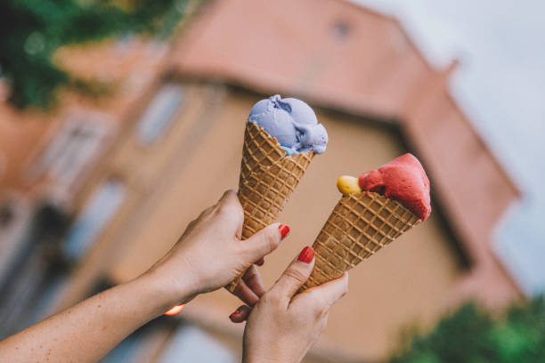 istock Hand holding lavender and fruit ice cream cone 1256153712
