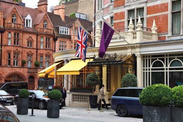 London, England - February 7, 2011: The Browns Hotel at dusk. The doorman standing and waiting for guests. The Browns is a 5 star hotel located in Mayfair.