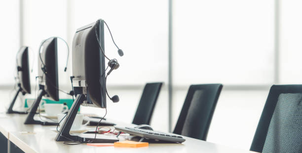 istock Call center computers and headsets all in office 1256154984