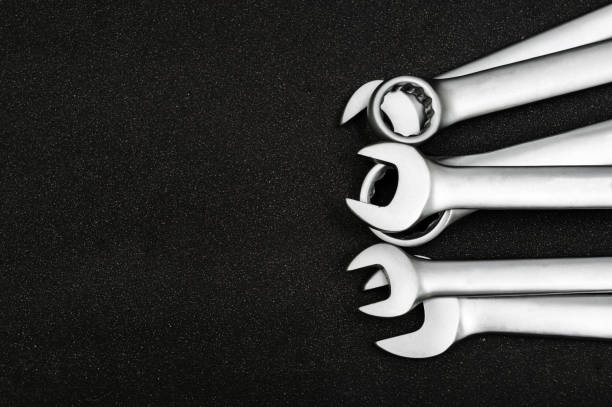 Group chrome plated wrench. Isolated on a black relief background. stock photo
