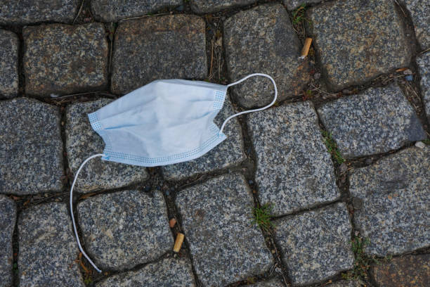 istock Surgical face masks thrown onto the pavement 1256156555