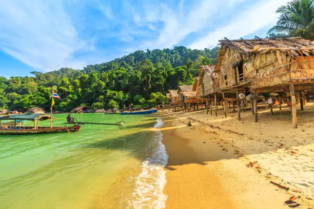 Traditional long-tail boats and houses of Moken tribe Village or Sea Gypsies and tropical waters of Surin Islands in Thailand, Phang Nga. Fisherman village landscape of Ko Surin Marine National Park.