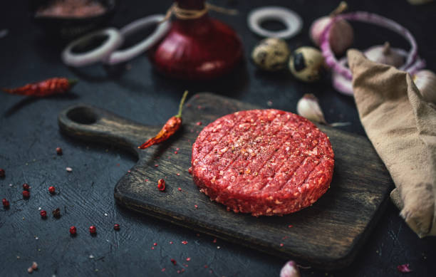 istock Raw minced beef burgers with spices and ingredients 1256156764